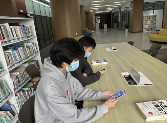 图为金年会师生正在图书馆内答题。